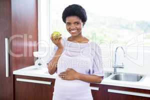 Pregnant woman holding apple