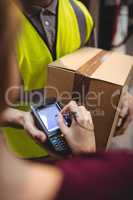 Woman signing on device to delivery parcel