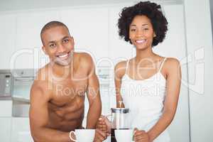 Happy couple drinking coffee in the kitchen