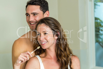 Young couple brushing their teeth at home