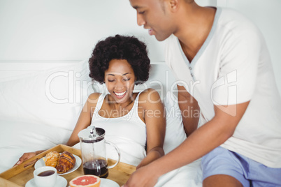 Handsome man bringing breakfast to his girlfriend
