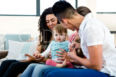 three women playing with an adorabl/e baby