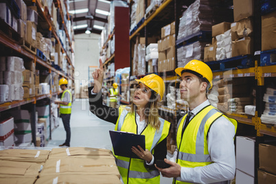 Warehouse managers looking at clipboard