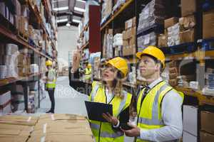 Warehouse managers looking at clipboard