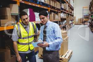 Manager showing tablet to worker