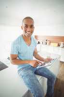 Smiling man using tablet in the kitchen