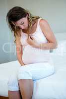 tired pregnant woman looking at her stomach