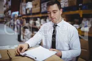 Warehouse manager looking at clipboard