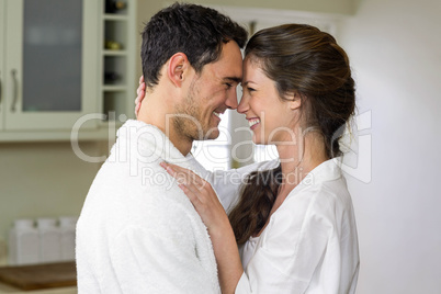 Young couple in bathrobe cuddling each other