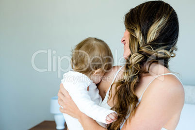 smiling brunette woman holding a baby