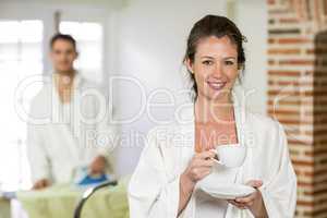Beautiful woman in bathrobe having a cup of tea