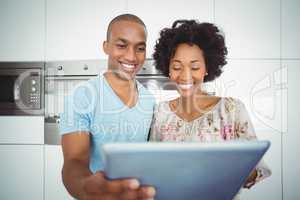Smiling couple using tablet together