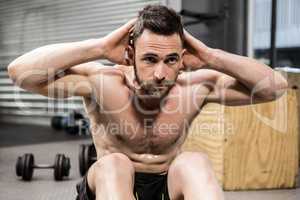 Shirtless man doing abdominal crunches