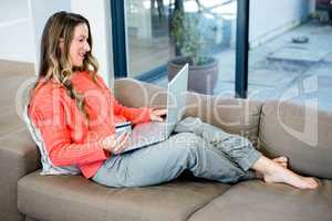 smiling woman on her laptop with her credit card