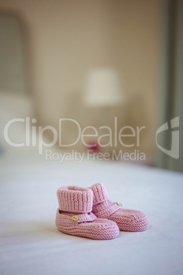 View of baby shoes on a bed