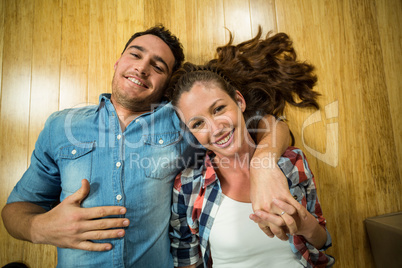 Young couple lying on floor in their house