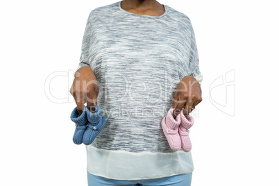 Pregnant woman holding baby shoe