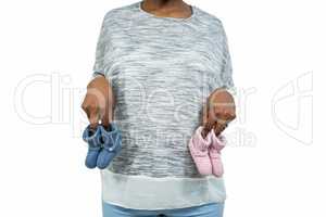 Pregnant woman holding baby shoe