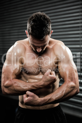 Shirtless man flexing arms