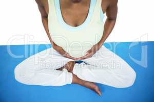 Pregnant woman meditating on mat