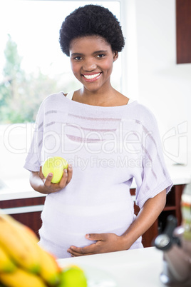 Pregnant woman holding apple