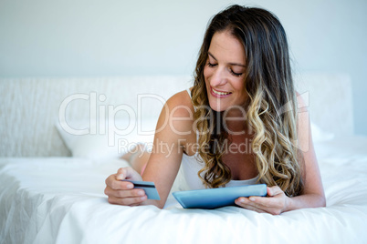 smiling woman holding her tablet and credit card