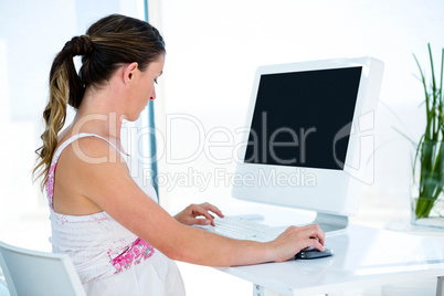 pregnant  businesswoman typing on her computer