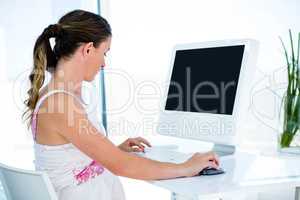 pregnant  businesswoman typing on her computer