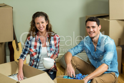 Young couple unpacking carton boxes