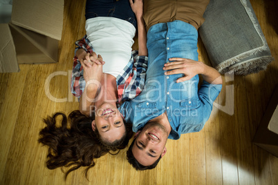 Young couple lying on floor in their new house