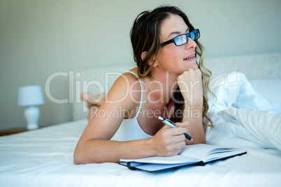 smiling woman with glasses writing in a book