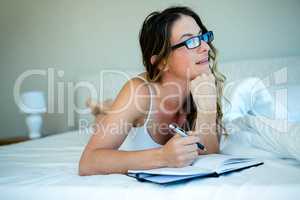 smiling woman with glasses writing in a book