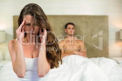 Upset couple sitting on bed