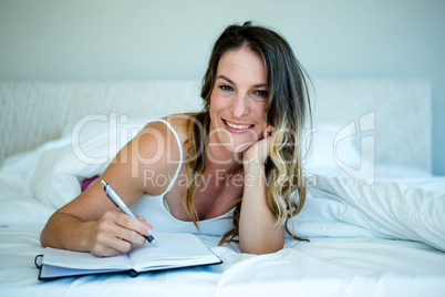 smiling woman writing in a notepad