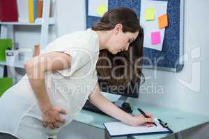 Pregnant woman writing on clipboard