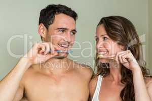 Young couple brushing their teeth at home
