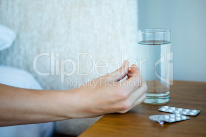 Tray of pills next to a glass of water