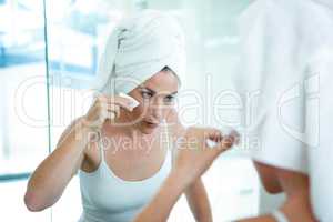 woman cleaning her skin in the mirror