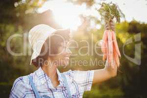 Smiling woman holding carrots