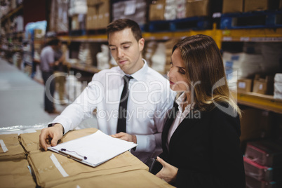 Warehouse managers looking at clipboard