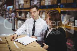 Warehouse managers looking at clipboard