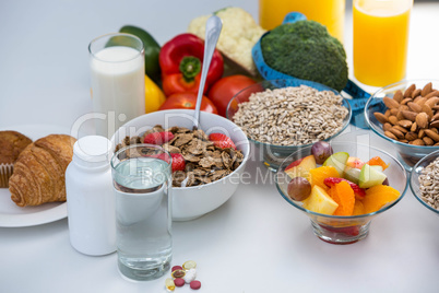 View of bowl of cereals, pills and food