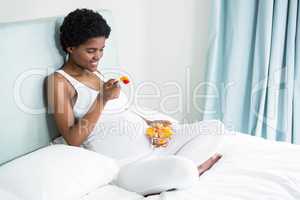 Pregnant woman eating fruit salad