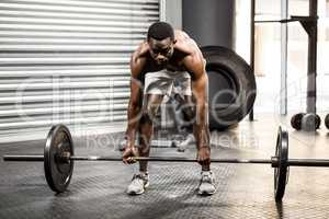 Shirtless man lifting barbell