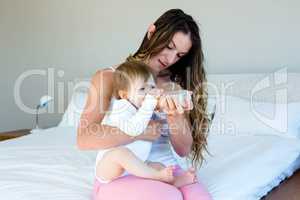 smiling woman bottle feeding a baby