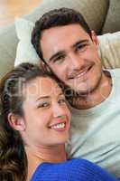 Portrait of young couple lying together on sofa