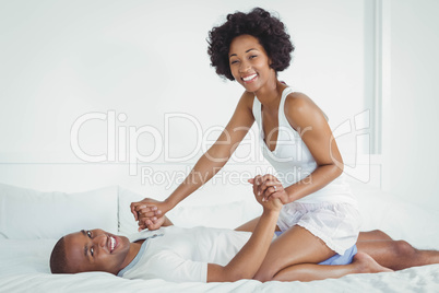 Happy couple playing on the bed