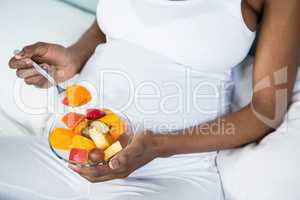 Pregnant woman eating fruit salad