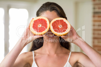 Young woman holding slices of blood orange