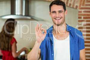Portrait of young man gesturing in kitchen